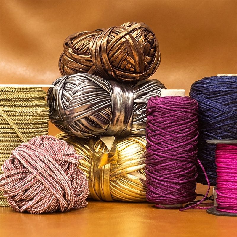Colorful spools of yarn on a wooden surface with a brown background