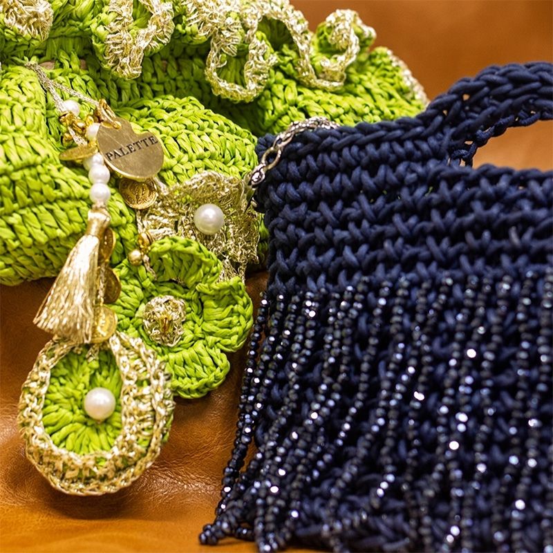 Close-up of green and blue textured bags  with decorative elements on a brown surface - Palette by Rishma