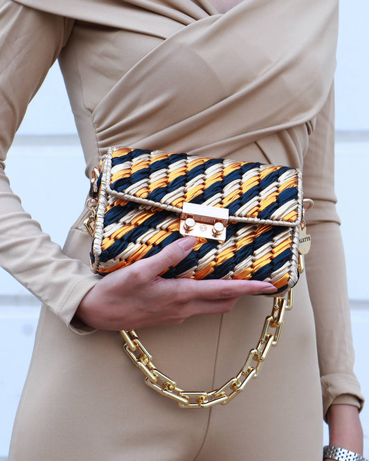 Palette by Rishma Panthera Bag worn as a clutch — black and gold evening bag in use