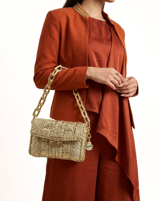 Palette by Rishma Solis Bag worn as a clutch — warm gold evening bag in use